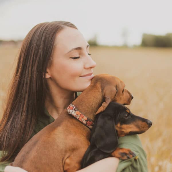 Una mujer abrazando a su perro de raza teckel